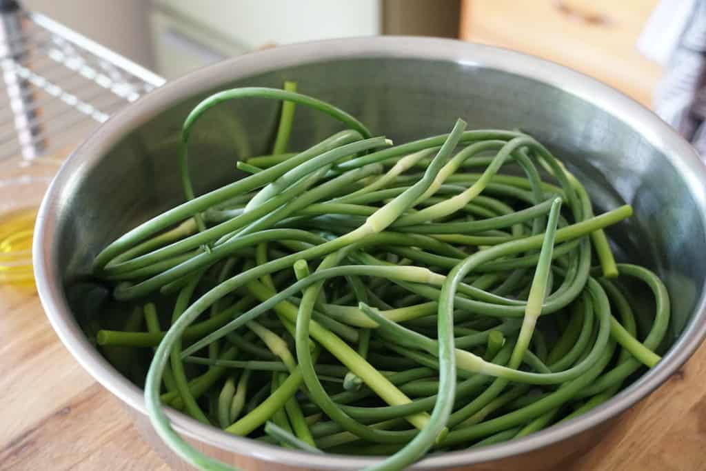 Bowl filled with trimmed garlic scapes