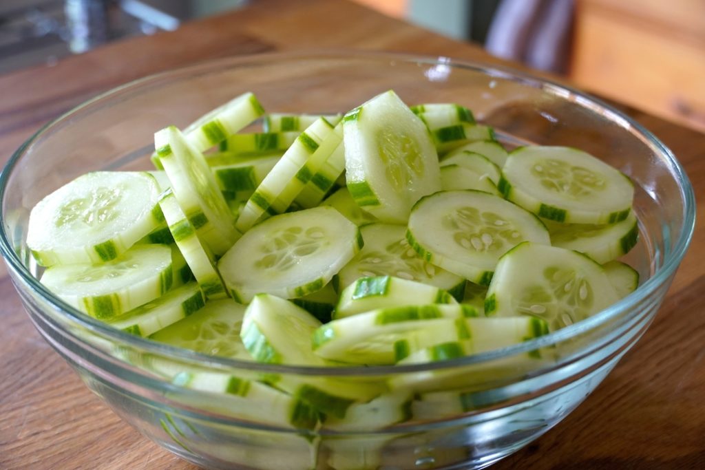 Cucumbers peeled and sliced for a creamy cucumber salad recipe.