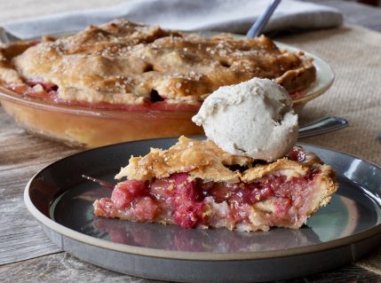 A slice of HOMEMADE RHUBARB PIE topped with vanilla ice cream