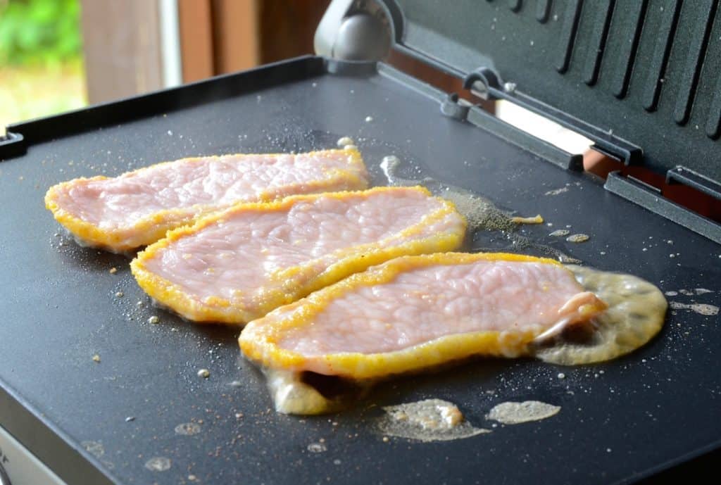 Peameal bacon sizzling on the griddle