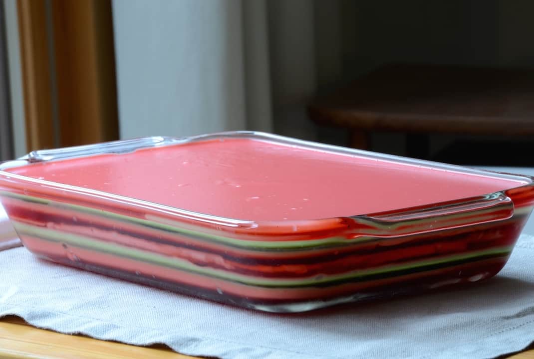 The various layers of the jello chilled in a casserole dish