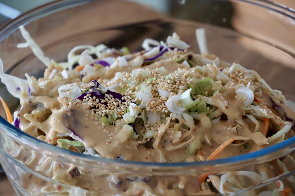 The prepared coleslaw with a drizzle of the dressing
