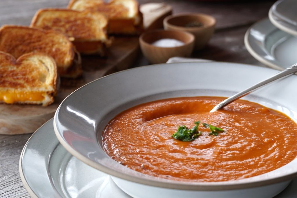 A bowl of Tomato Soup served with grilled cheese