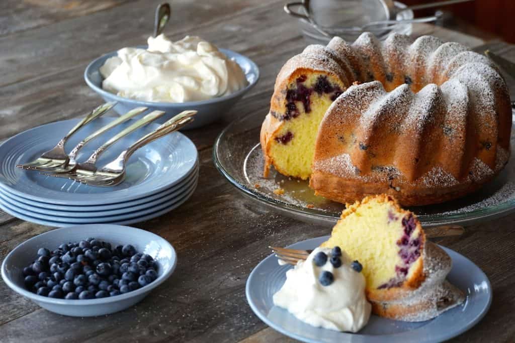 Blueberry Bundt Cake served with whipped cream and few fresh berries