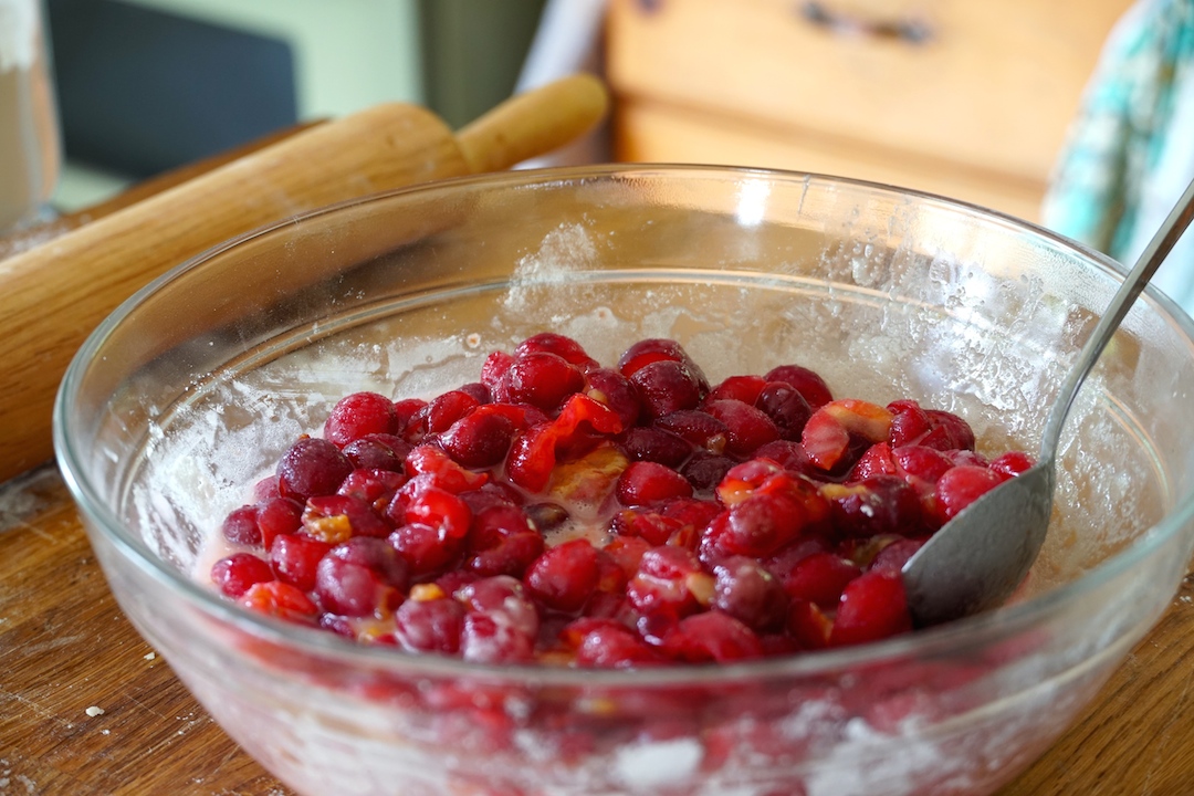 The sour cherries tossed in a bowl with sugar, lemon juice and few drops of pure almond extract