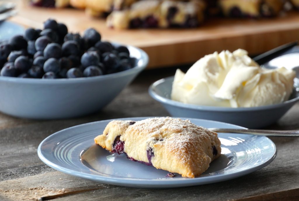 Serve blueberry scones with extra blueberries and whipped cream