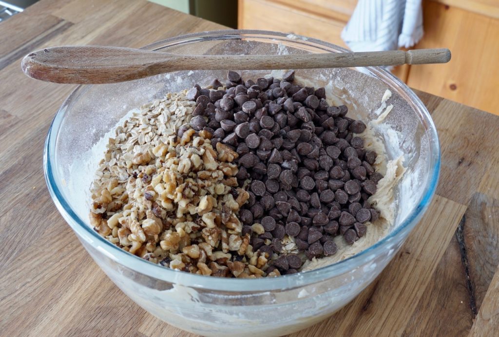 Adding chocolaste chips, walnuts and oats to the cookies