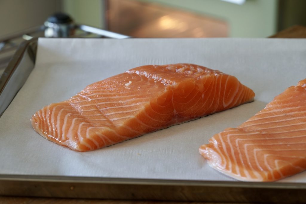 Fillets of salmon on a parchment-lined baking sheet.