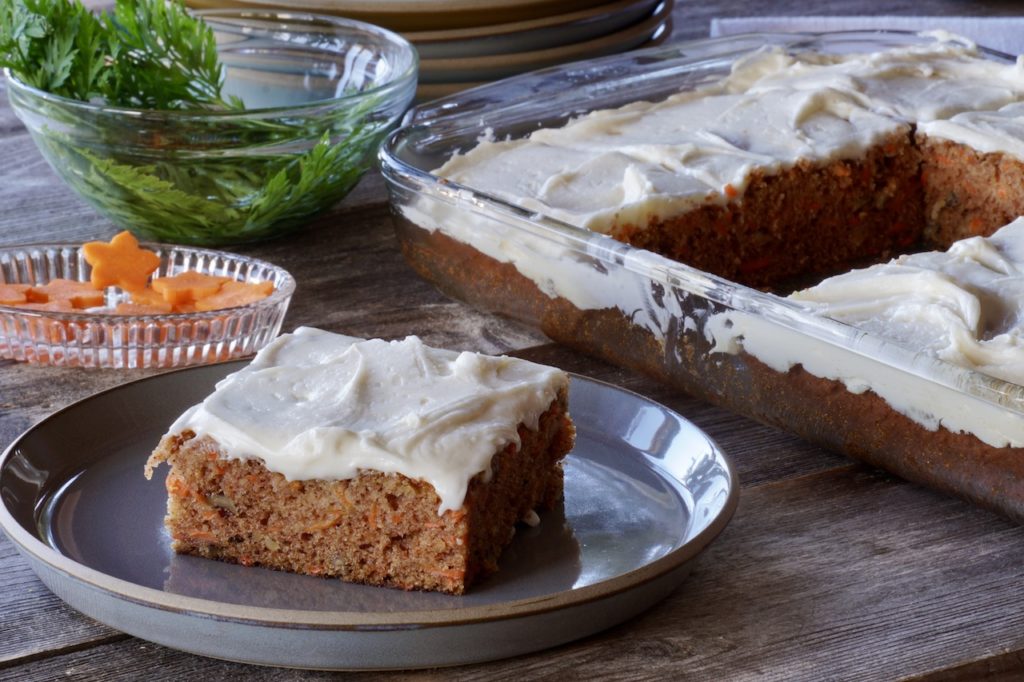 Squares of the carrot cake served with a topping of lemony, cream cheese icing.