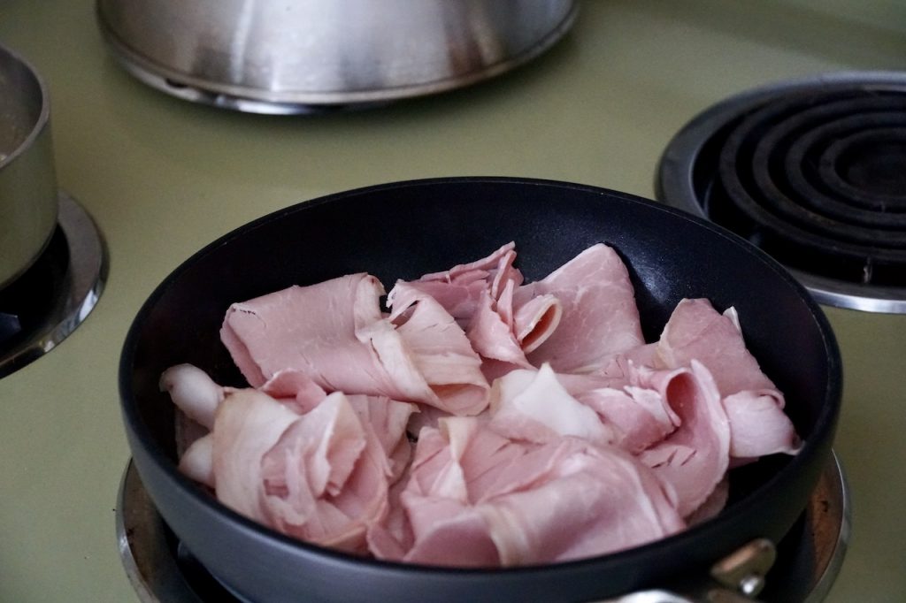 Ham being warmed in a skillet