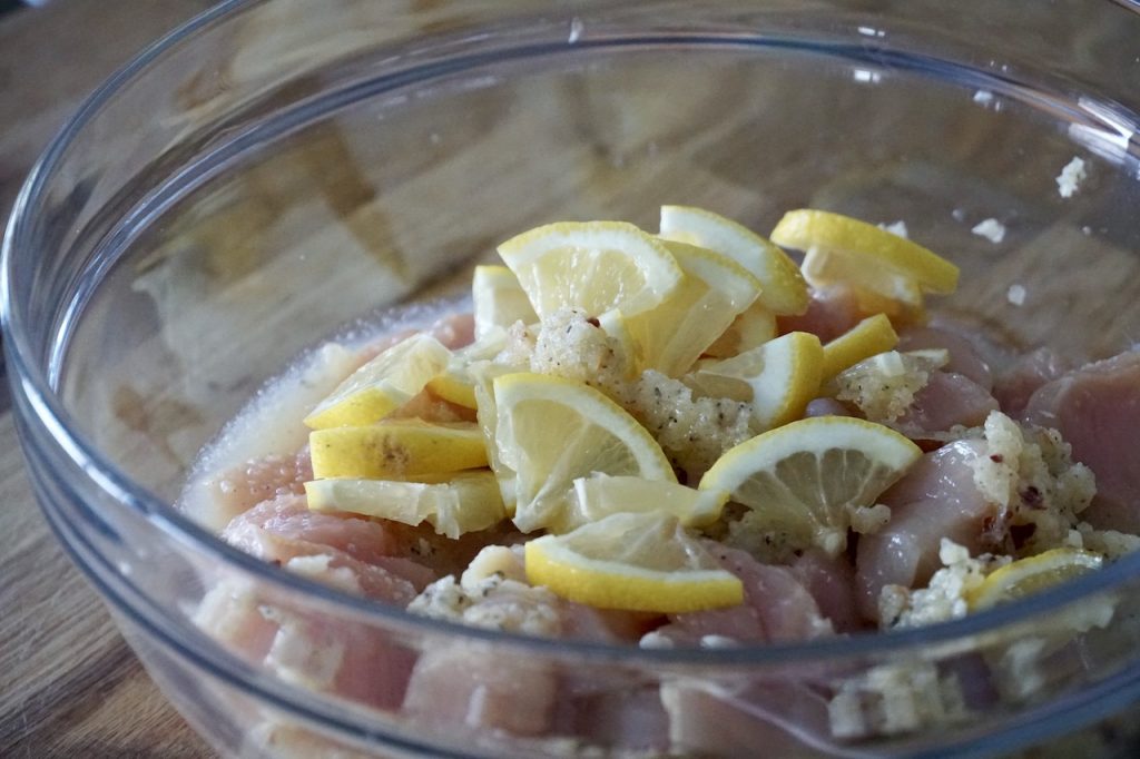 The chicken pieces readsy to be tossed with the marinade and sliced lemons
