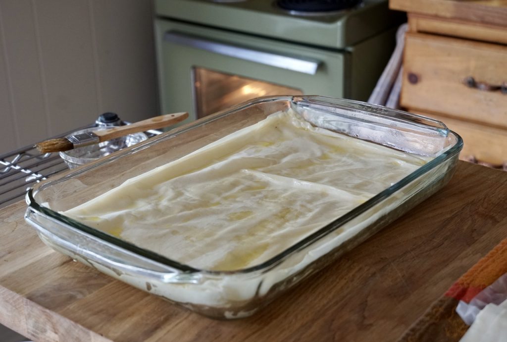 Layers of phyllo dough line the baking dish