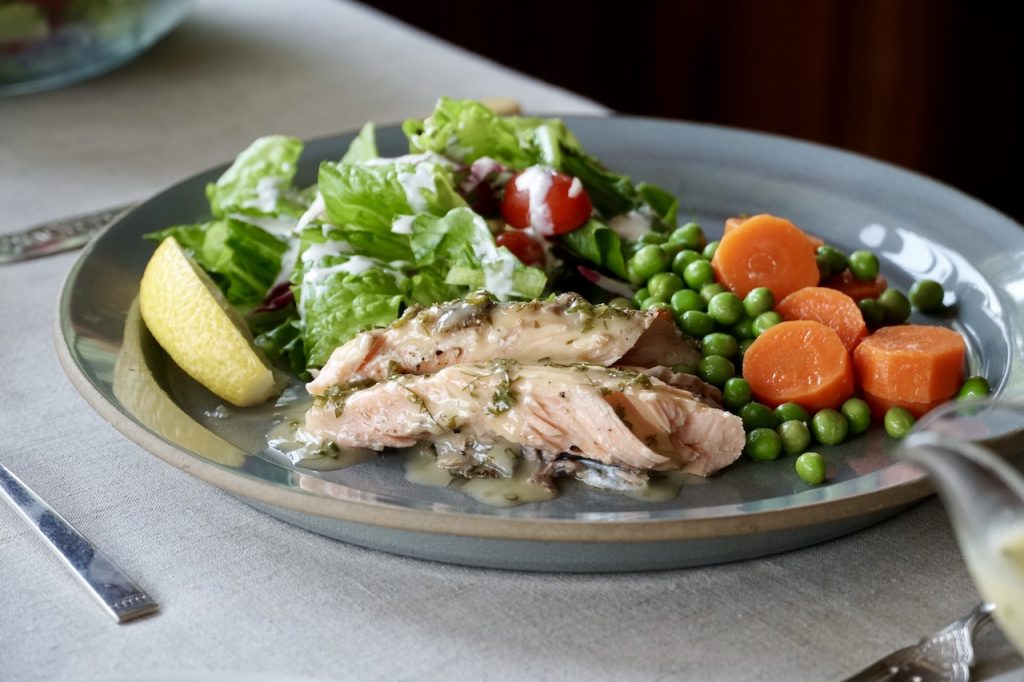 The trout served with a fresh salad and sauteed peas and carrots