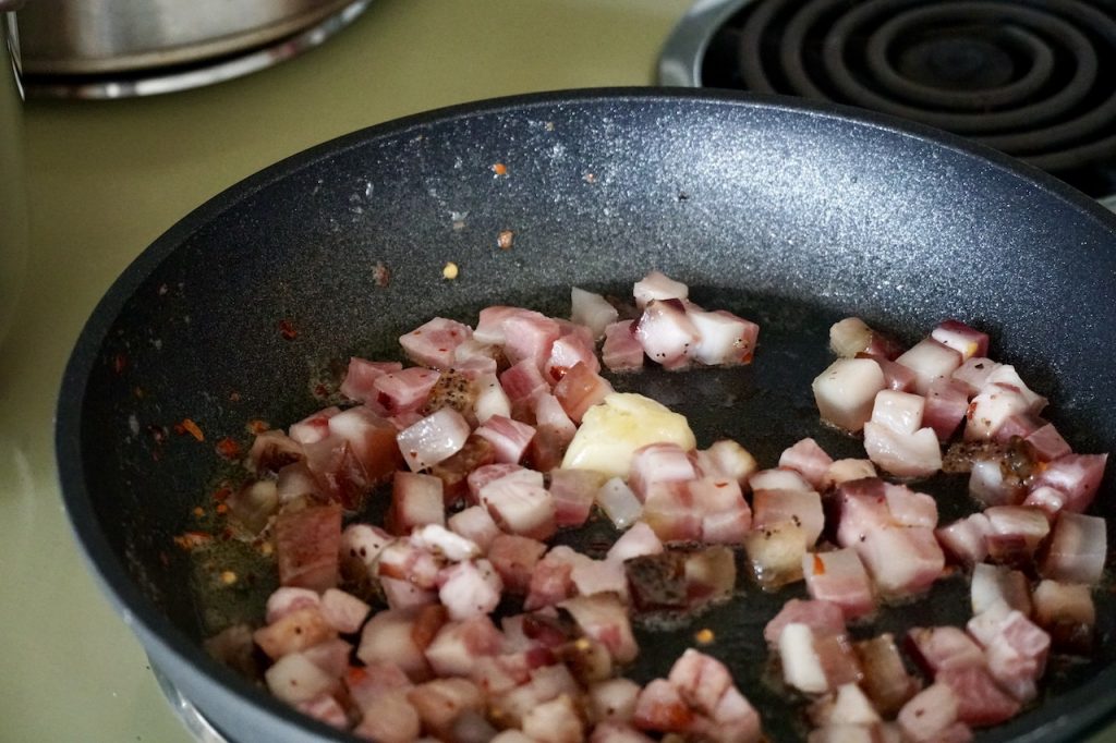 Frying up the guanciale with chili flakes and garlic