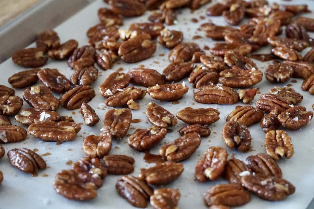 The pecans tossed in the sugar and spices, sprinkled with sea salt flakes