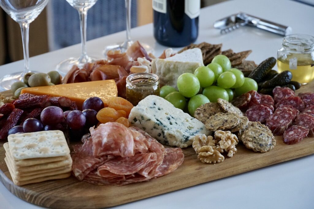 A selection of cured meats, cheese, fruit, nuts and condiments for an easy snack board