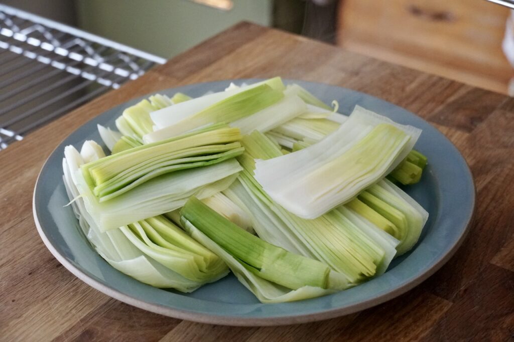 Steamed leeks cooling before being layered in the casserole dish