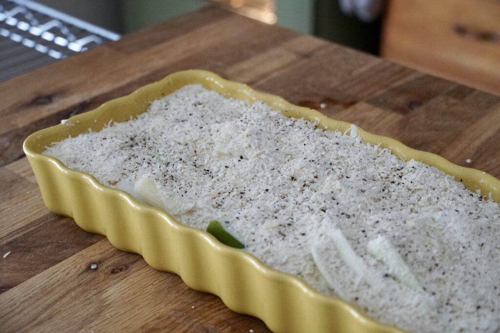 The leeks are layered in a casserole dish then covered in the creamy cheese sauce