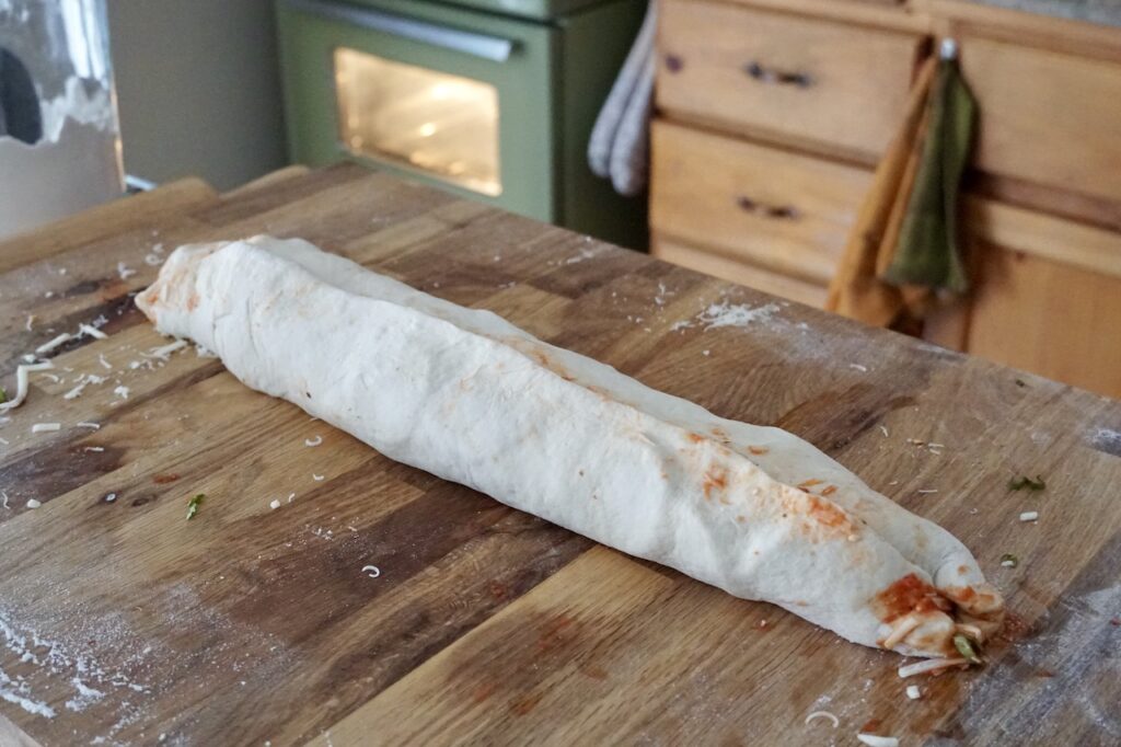 The pizza is rolled up jelly-roll style.