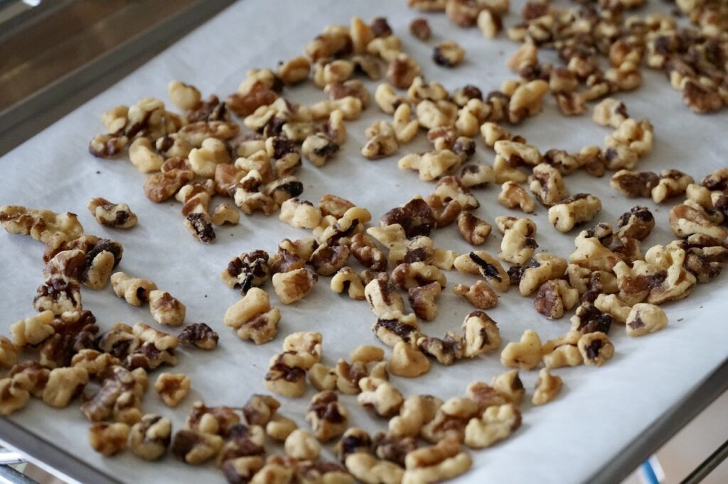 A baking sheet with the toasted, chopped walnuts