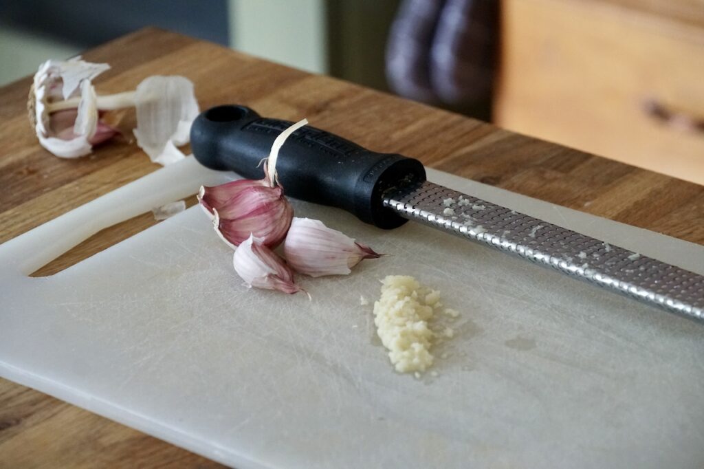 A clove of garlic grated using a microplane