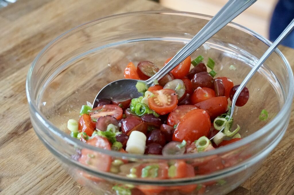 Cherry tomatoes, red grapes and green onions tossed in the dressing