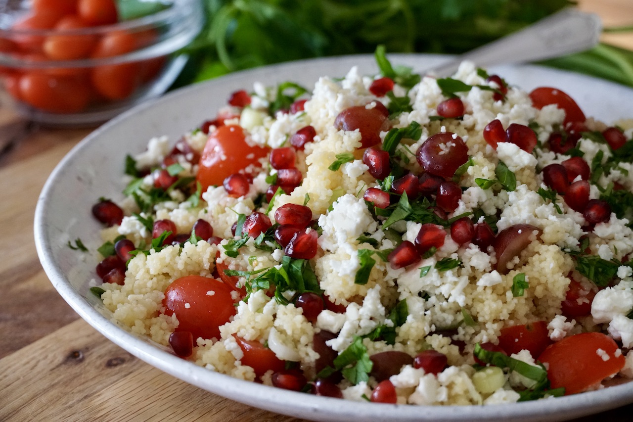 The easy summer couscous salad topped with pomegranate seeds