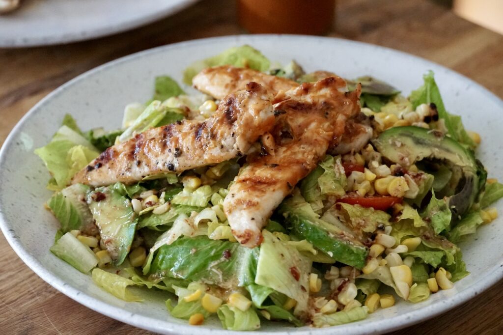 The grilled avocado salad topped with strips of barbecued chicken