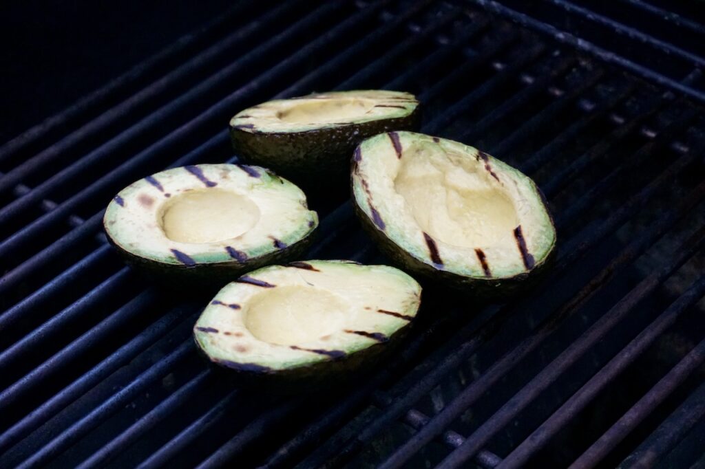 Avocado halves scored beautifully on a hot grill.