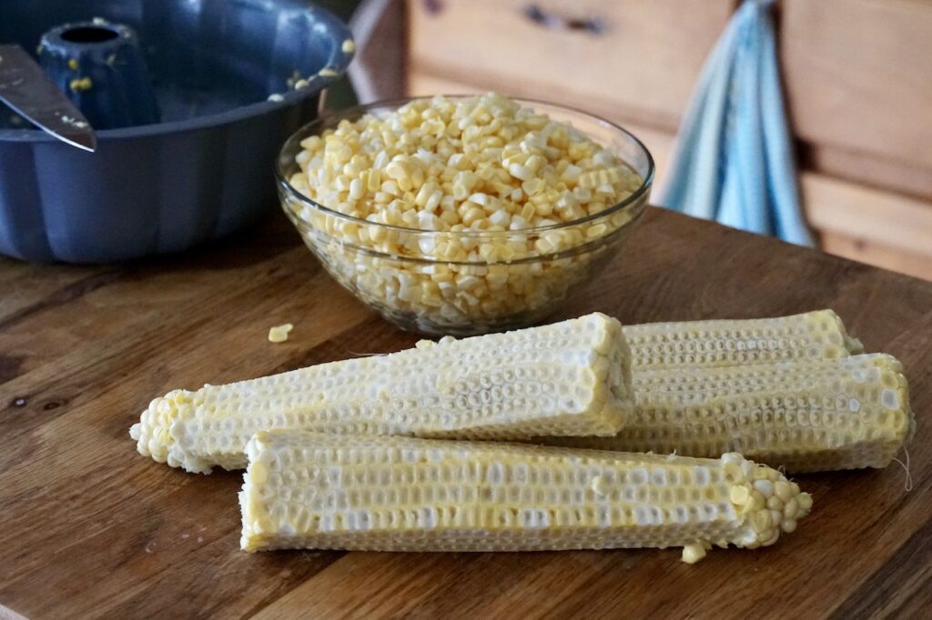 A bowl of corn kernels and cobs.