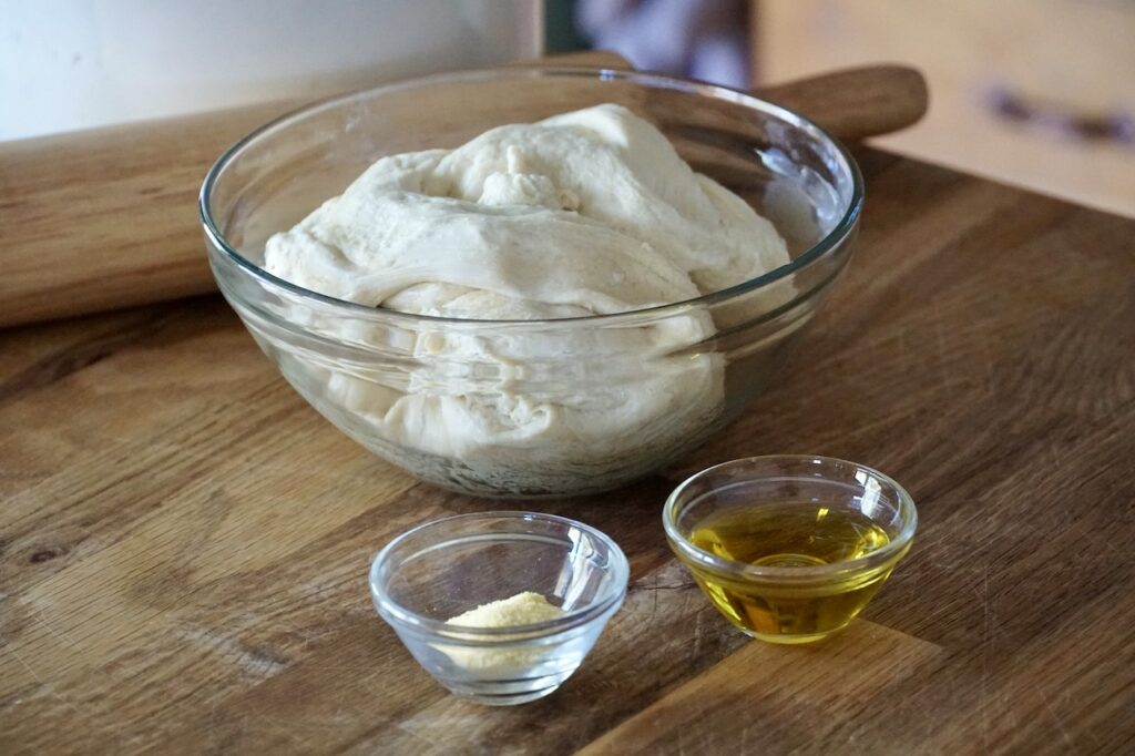 Pizza dough, olive oil and cornmeal.
