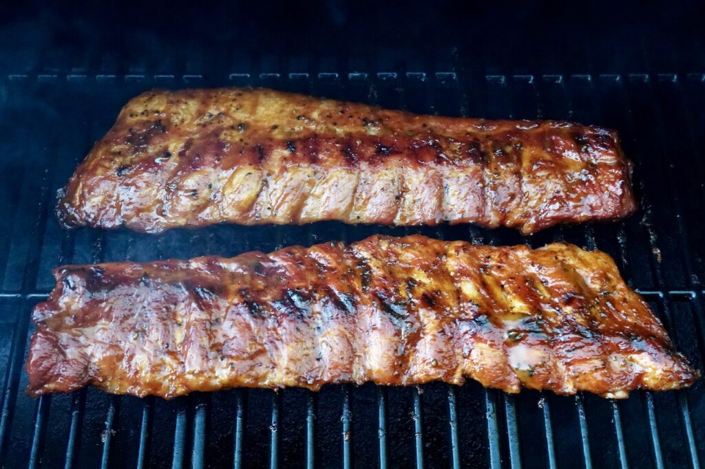 Pork baby back ribs on the grill brushed with WATC BBQ Sauce