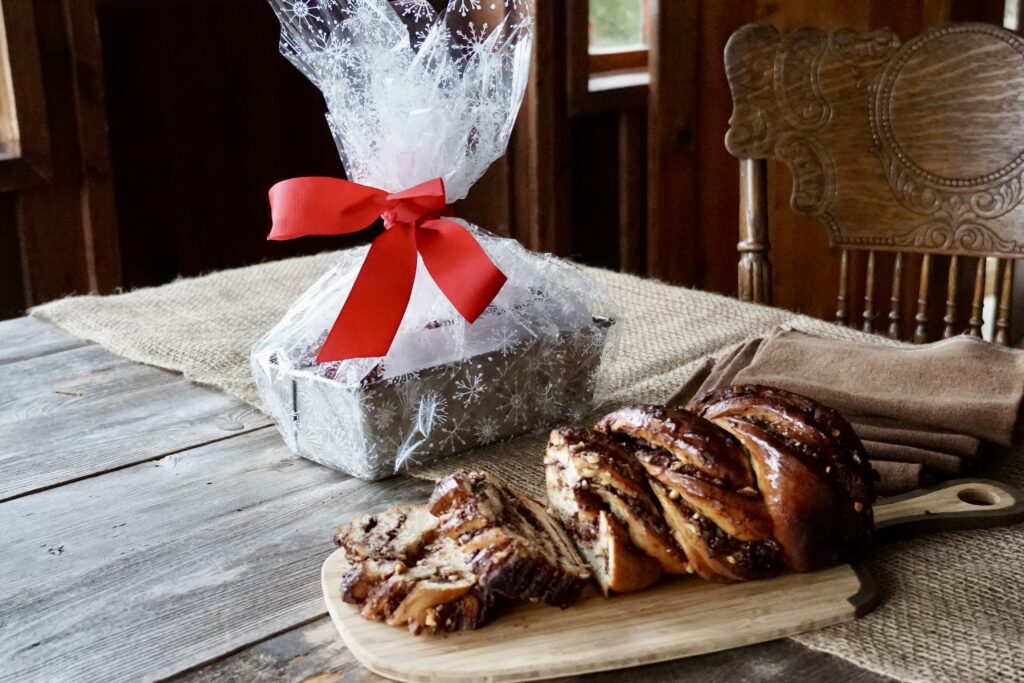 A Chocolate-Hazelnut Babka ready to be enjoyed and a second one wrapped as a gift.