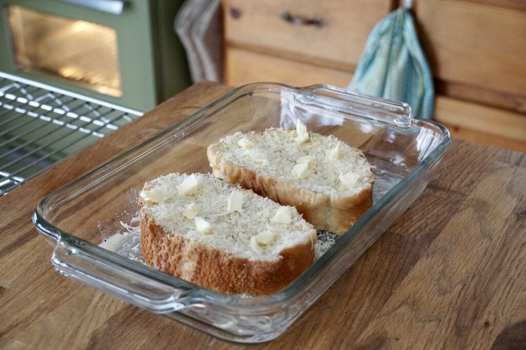 The sliced sprinkled with Parmesan, dotted with flecks of butter.