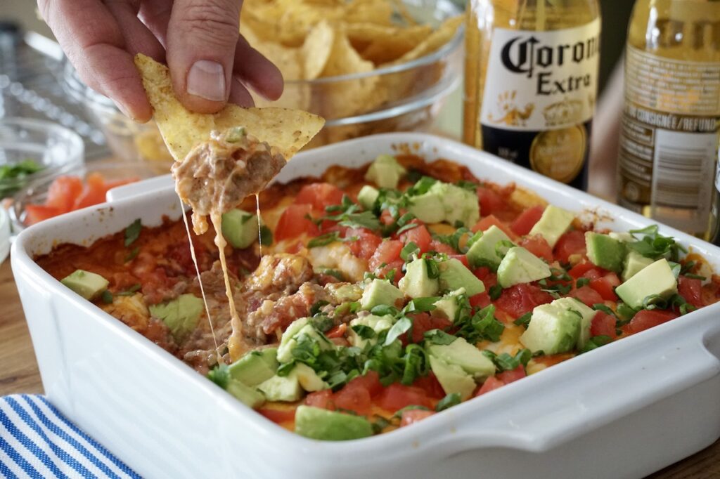 The dip served with tortilla chips and cold beer.