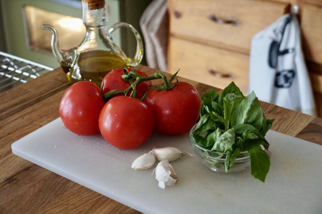 Garden fresh tomatoes, fresh basil and cloves of garlic.