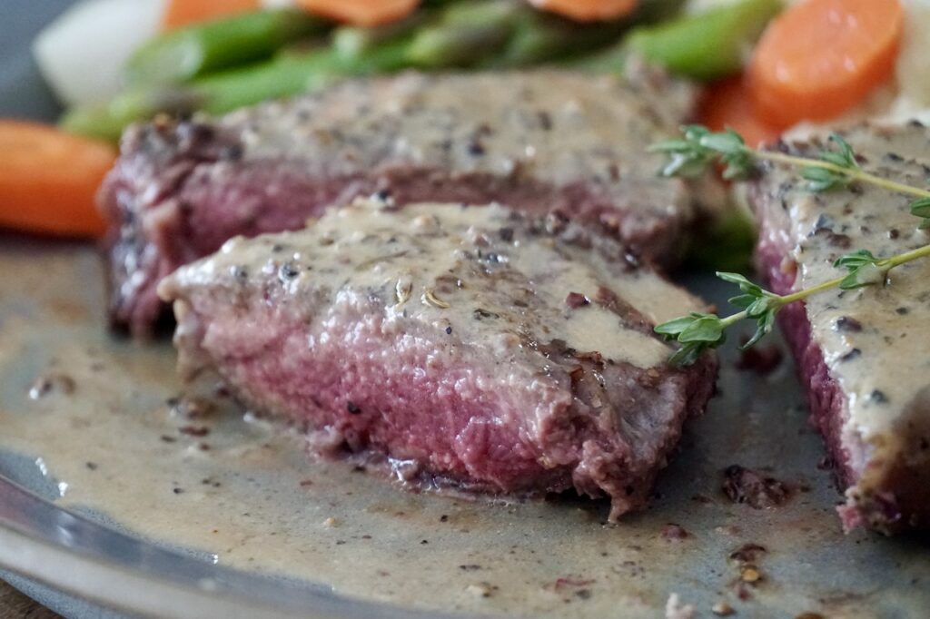 The steak cut open revealing a perfect medium doneness.