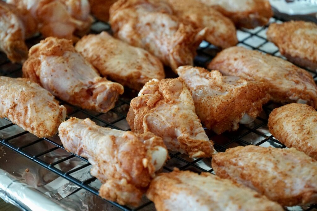 The seasoned wings placed onto a wire rack, ready for the oven.
