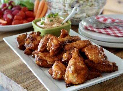 Oven-Baked Chicken Wings presented on a platter with a tangy dipping sauce.