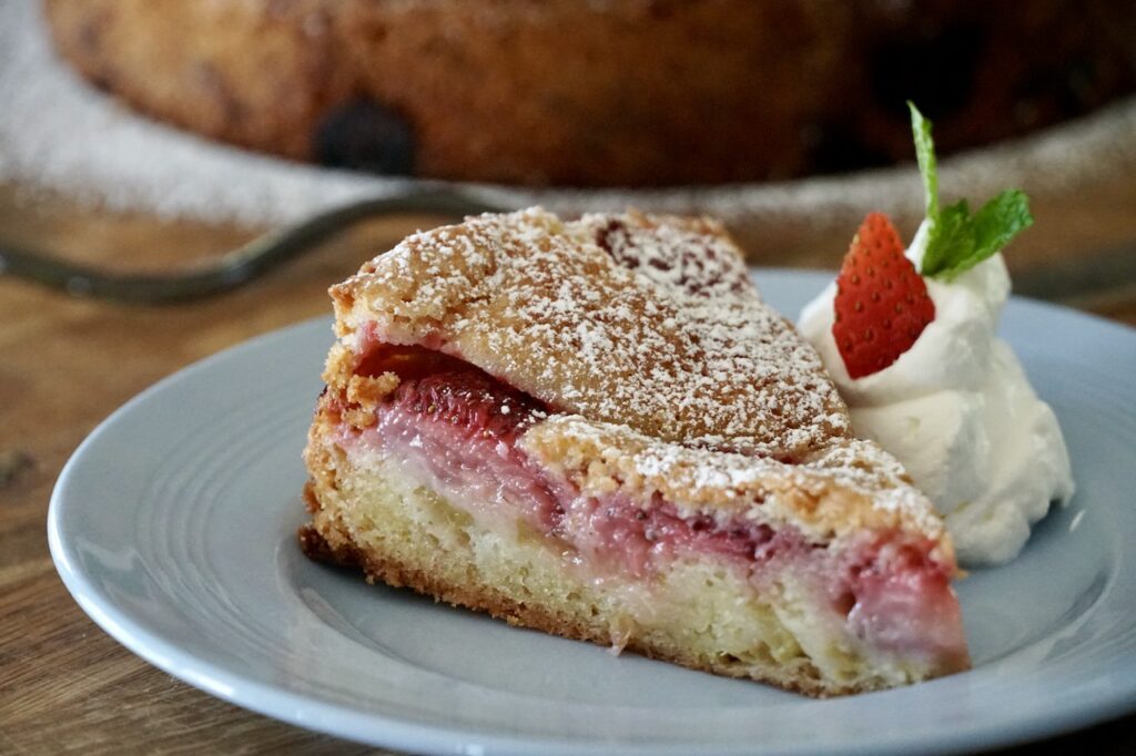 Strawberry rhubarb cake served with whipped cream.