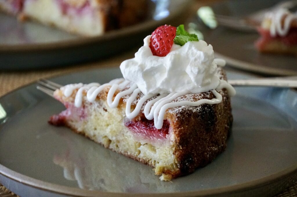 Strawberry rhubarb cake served with a drizzle of almond glaze.