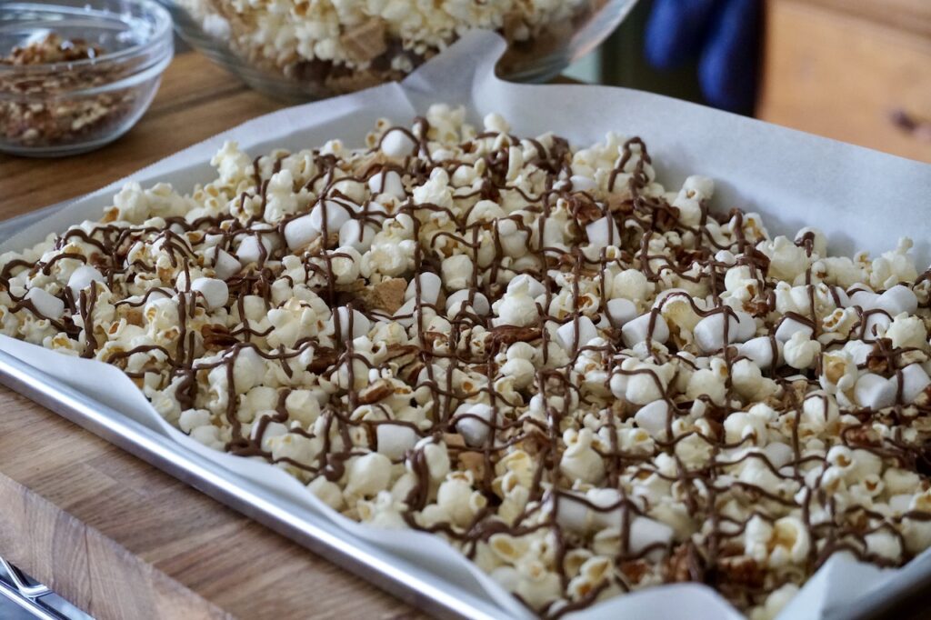 A parchment-lined baking sheet of freshly prepared S'Mores Popcorn.