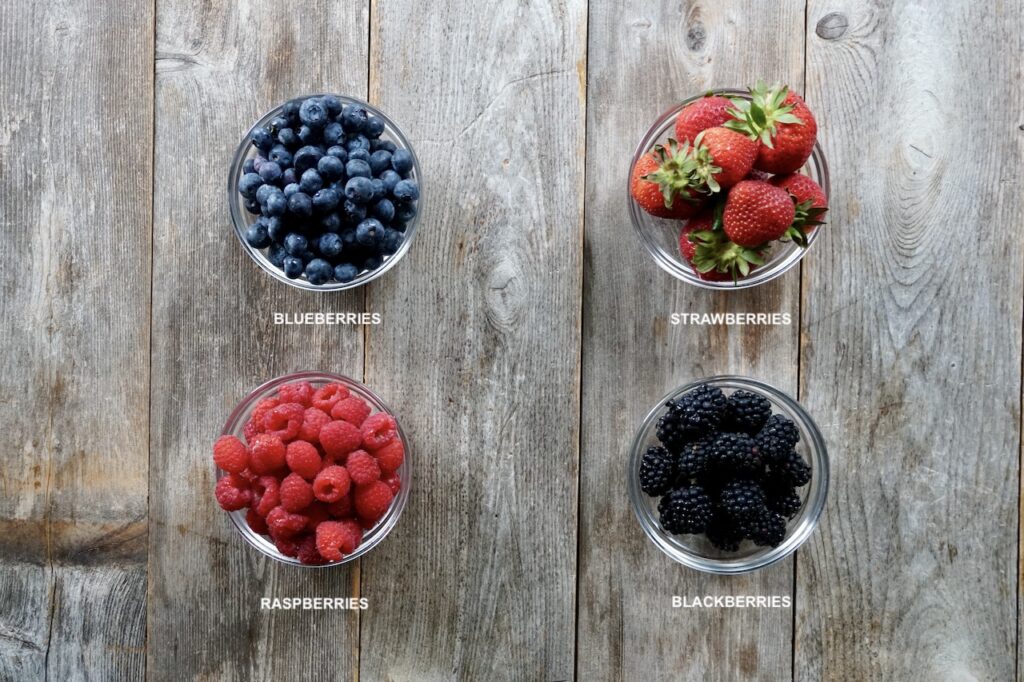 Bowls of raspberries, blueberries, blackberries and strawberries.
