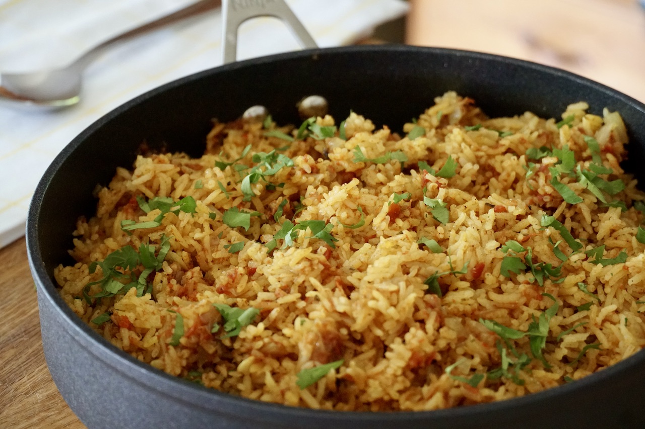 The skillet of rice with the rice within fluffed up.