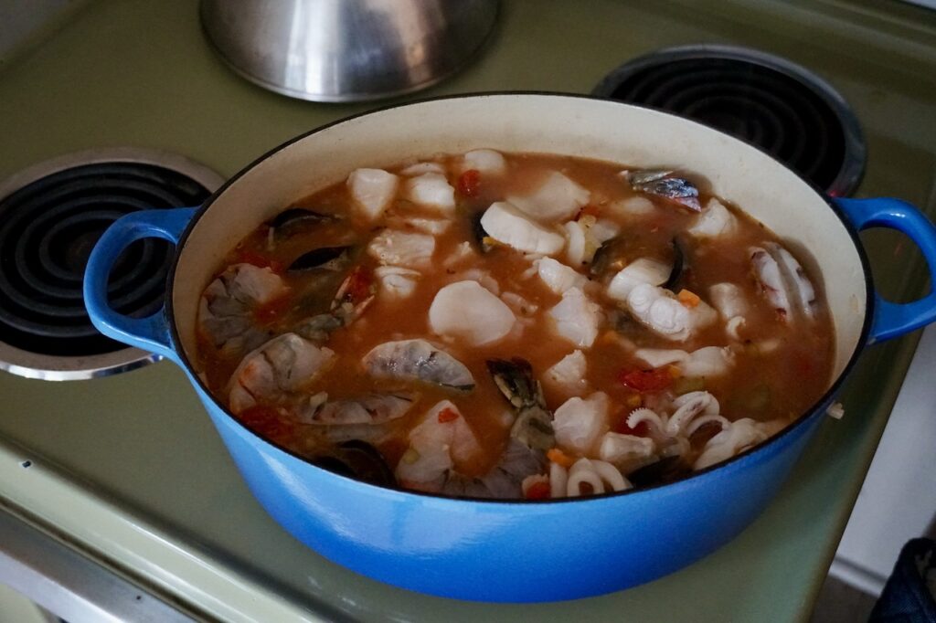 A large Dutch oven brimming with cioppino fisherman's stew.