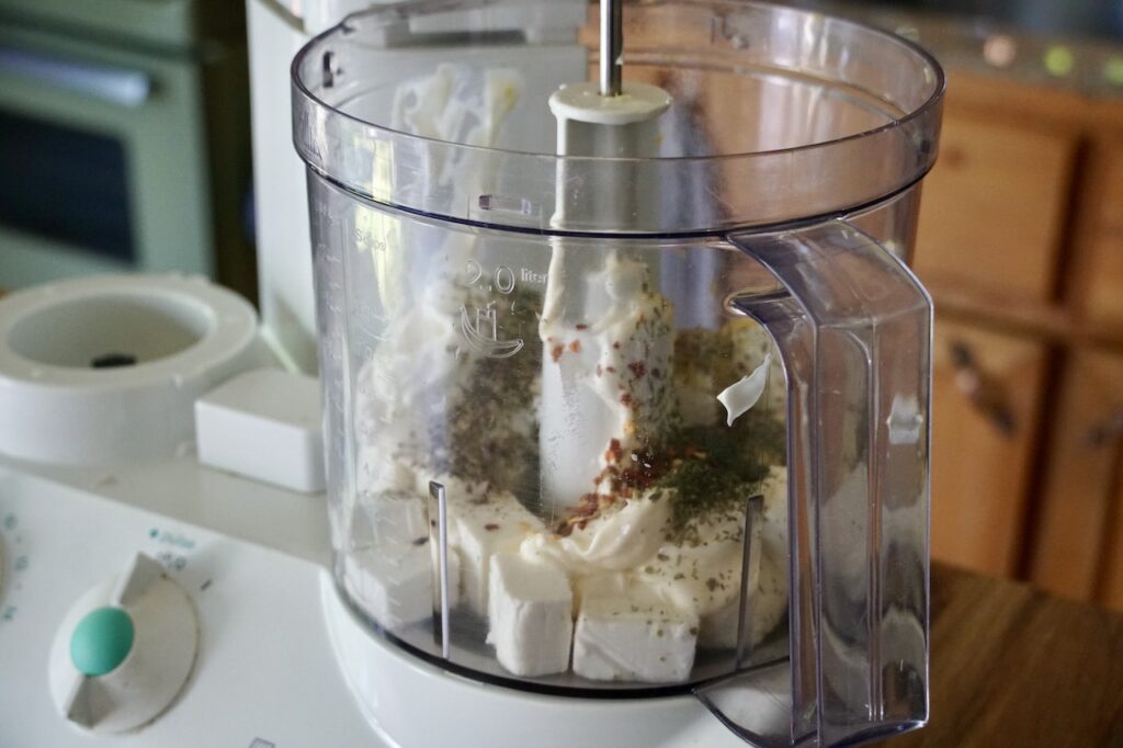 A food processor filled with all of the ingredients to make the dip.