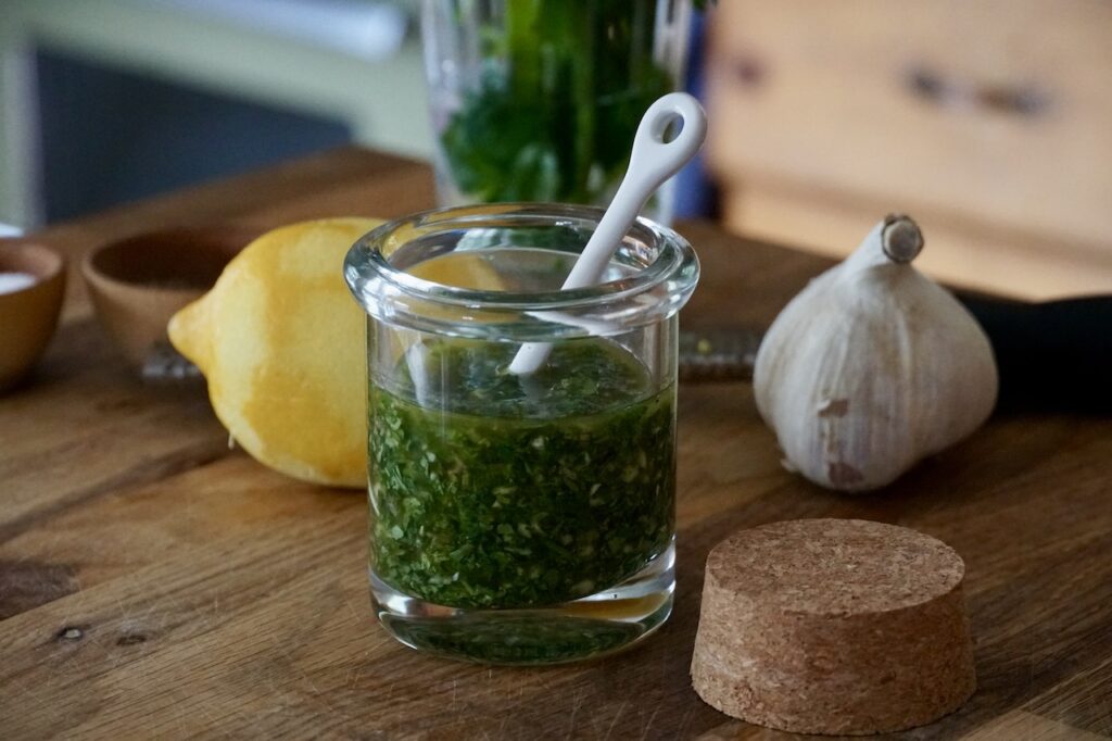 A bottle of gremolata made with lemon, parsley, garlic, olive oil and anchovies.