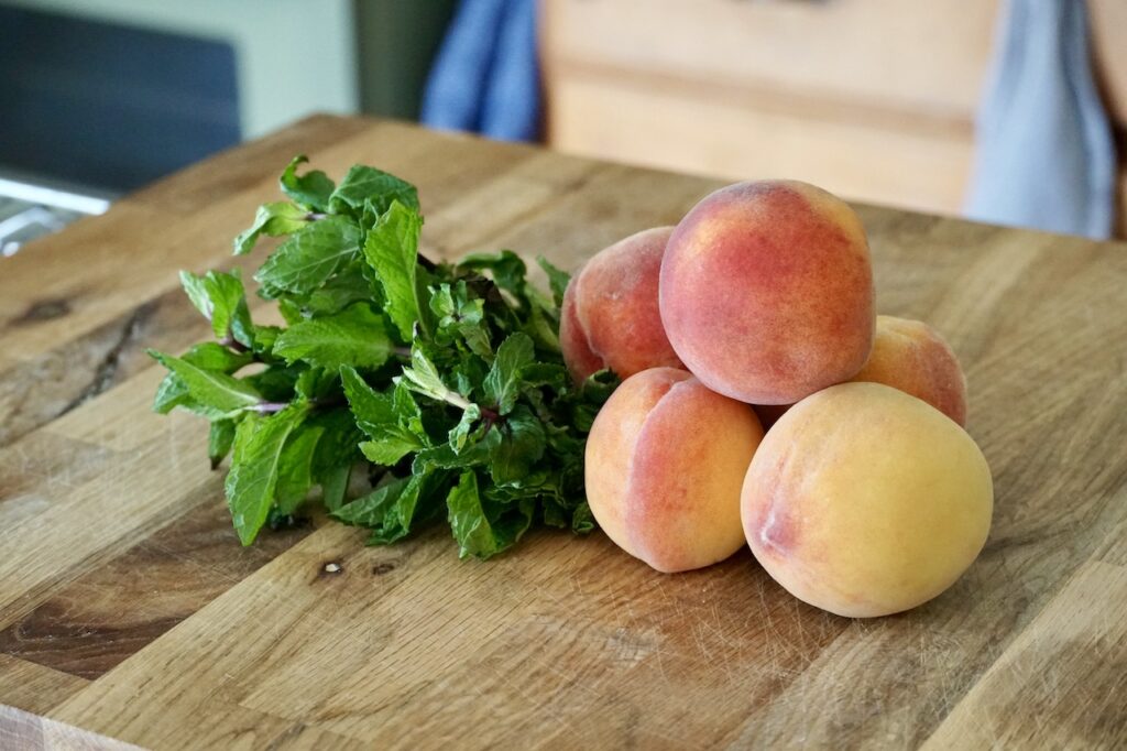 Fresh peaches and bunch of fresh mint.