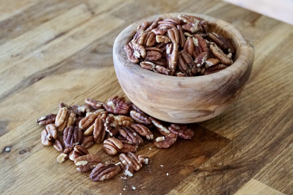 A bowl of pecan pieces and halves.
