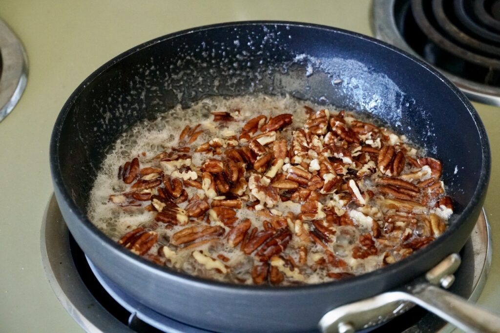 The skillet containing the butter pecan sauce.